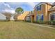 Side view of tan house with blue shutters, landscaping, and walkway at 1933 Island Walk Dr, Orlando, FL 32824