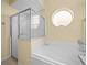 Bathroom features a shower, a garden tub, and a round window at 220 Brunello Dr, Davenport, FL 33897