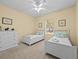 Bright bedroom with two twin beds, dresser, and window at 220 Brunello Dr, Davenport, FL 33897
