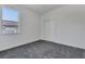 Bedroom with grey carpet, window, and double doors at 223 Elm Ct, Kissimmee, FL 34759