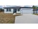 New construction home with gray exterior, two-car garage, and driveway at 223 Elm Ct, Kissimmee, FL 34759