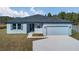 Newly built home with light blue exterior, two-car garage, and landscaping at 223 Elm Ct, Kissimmee, FL 34759