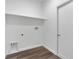 Laundry room with white walls, wood-look flooring, and shelving at 223 Elm Ct, Kissimmee, FL 34759