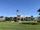 Community clubhouse with a flag and manicured lawn at 2438 Yellow Brick Rd, St Cloud, FL 34772