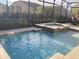 Screened-in pool with integrated spa and lovely landscaping creates a relaxing outdoor oasis at 3034 Boating Blvd, Kissimmee, FL 34746
