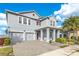 Two-story house with gray siding, two-car garage, and landscaped yard at 3074 White Horse Ct, Kissimmee, FL 34746