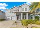 Two-story house with gray siding, two-car garage, and manicured landscaping at 3074 White Horse Ct, Kissimmee, FL 34746