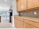 Kitchen with light wood cabinets, granite countertops, and tile backsplash at 3074 White Horse Ct, Kissimmee, FL 34746