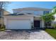 Charming two-story home with a brick driveway, attached garage, and well-manicured lawn at 4626 Cumbrian Lakes Dr, Kissimmee, FL 34746