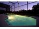 Inviting screened pool and spa at night with lighting at 4626 Cumbrian Lakes Dr, Kissimmee, FL 34746