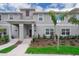 Two-story townhome with light gray exterior, walkway, and landscaping at 4816 Memories Ln, Kissimmee, FL 34746