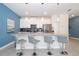 Modern kitchen featuring a large island with seating, stainless steel appliances, and grey countertops at 4816 Memories Ln, Kissimmee, FL 34746