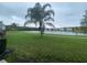 Lakefront backyard with lush grass and palm trees at 6660 S Goldenrod Rd # 126B, Orlando, FL 32822