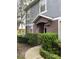 Two-story townhome with brown door and gray siding, landscaped walkway at 6660 S Goldenrod Rd # 126B, Orlando, FL 32822