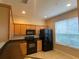 Kitchen boasts light wood cabinets, black appliances, and a large window at 6660 S Goldenrod Rd # 126B, Orlando, FL 32822