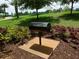 Octagonal community grill on a stand with landscaping at 7509 Mourning Dove Cir # 304, Reunion, FL 34747