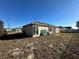 Rear view of house with some yard debris at 869 Colville Dr, Kissimmee, FL 34759
