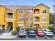 Exterior view of a yellow building with parking and landscaping at 8848 Villa View # 106, Orlando, FL 32821
