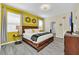 Bedroom with king-size bed and yellow accent wall at 9194 Sommerset Hills Dr, Davenport, FL 33896