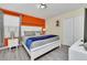 Spacious bedroom with a king-size bed, nightstands, and an orange accent wall at 9194 Sommerset Hills Dr, Davenport, FL 33896