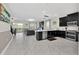 Modern kitchen with black cabinets, stainless steel appliances, and an island at 9194 Sommerset Hills Dr, Davenport, FL 33896