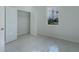 Bright bedroom with white-tiled floors, a closet, and a window bringing in natural light at 9505 Luna Dr, St Cloud, FL 34773