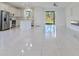 Bright open-concept living space with white tile flooring and stainless steel appliances in the adjacent kitchen at 9505 Luna Dr, St Cloud, FL 34773