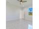 Bright main bedroom with tile flooring, a ceiling fan, and a large window overlooking lush greenery, offering tranquility at 9505 Luna Dr, St Cloud, FL 34773