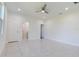 Airy main bedroom featuring white tile floors, a ceiling fan, and ensuite access, offering comfort and convenience at 9505 Luna Dr, St Cloud, FL 34773