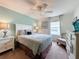 Comfortable bedroom with ceiling fan, dresser, and seating area at 993 Suffolk Pl, Davenport, FL 33896