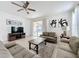 Spacious living room with a neutral color scheme, comfy furniture, and a large TV at 993 Suffolk Pl, Davenport, FL 33896
