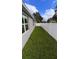 House backyard with a grassy lawn and a white vinyl fence at 115 W Murphy St, Davenport, FL 33837