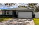 Gray house with white garage door and a brick driveway at 115 W Murphy St, Davenport, FL 33837