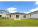 Home features a backyard with solar panels and grassy area at 1274 Fury St, Davenport, FL 33837