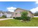 Tan house with two-car garage and landscaped yard at 1274 Fury St, Davenport, FL 33837