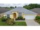 Single-Gathering home with gray roof, driveway, and landscaped yard at 135 Langham Dr, Davenport, FL 33897