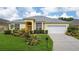 Single-story house with a gray roof and attractive landscaping at 135 Langham Dr, Davenport, FL 33897