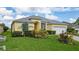 Yellow house with gray roof, well-manicured lawn and driveway at 135 Langham Dr, Davenport, FL 33897