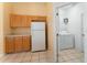 Bright kitchen features wood cabinets, white appliances, and tiled floor at 135 Langham Dr, Davenport, FL 33897