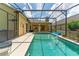 Inviting pool area with covered patio and lush landscaping at 135 Langham Dr, Davenport, FL 33897