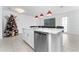 Kitchen island with white cabinets, quartz countertop, and stainless steel dishwasher at 1481 Discovery St, Davenport, FL 33896