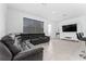 Open living area with sectional sofa, large TV, and tile floors at 1481 Discovery St, Davenport, FL 33896