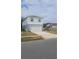 Two-story house with light gray siding, white garage door, and landscaping at 1511 Woodmont Blvd, Kissimmee, FL 34746