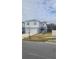 Two-story house with light gray siding, white garage door, and landscaping at 1511 Woodmont Blvd, Kissimmee, FL 34746
