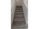 Gray carpeted staircase with white railing and neutral walls at 1511 Woodmont Blvd, Kissimmee, FL 34746