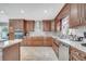 This kitchen features wood cabinets, stainless appliances, granite countertops, and a farmhouse sink at 212 Rontunda Dr, Kissimmee, FL 34758