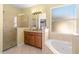 Bathroom with corner bathtub, glass shower, and wood cabinets at 2136 Laurel Blossom Cir, Ocoee, FL 34761