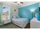 Bedroom with white bed, blue accent wall, and wood floors at 2136 Laurel Blossom Cir, Ocoee, FL 34761