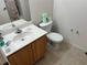 Bathroom with a toilet, sink, and light wood cabinets at 2200 San Christabolo Dr # 106, Kissimmee, FL 34741