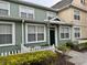 Two-story townhome with green siding, white picket fence, and landscaping at 2200 San Christabolo Dr # 106, Kissimmee, FL 34741